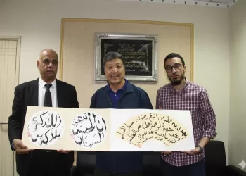 رئيس التحرير يستعرض لوحة خطية للفنان الصينى ورفيقه م. محمد مجدى