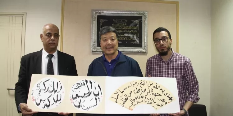 رئيس التحرير يستعرض لوحة خطية للفنان الصينى ورفيقه م. محمد مجدى